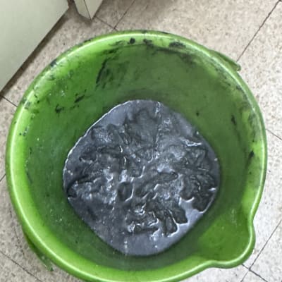 דלי ירוק עם מים מלוכלכים על רצפה