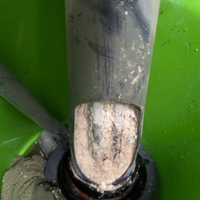 צינור עם אבנית בתוך דלי ירוק