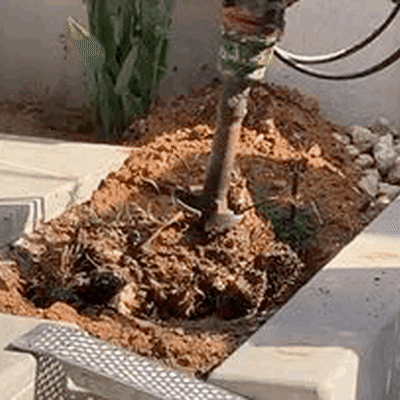 מכונה חופרת באדמה ליד שביל מרוצף