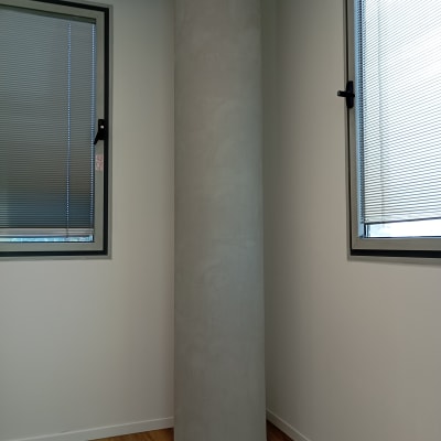 עמוד עגול בחדר עם חלונות ותריסים