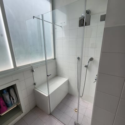 מקלחון זכוכית עם ראש מקלחת ומושב מובנה