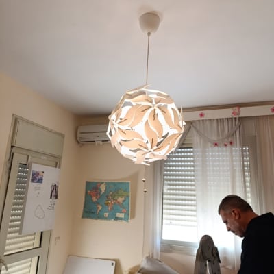 חשמלאי עובד על סולם ליד מנורה תלויה