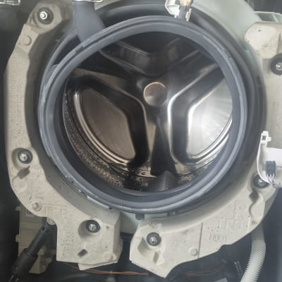 תוף מכונת כביסה פתוח עם חלקים פנימיים גלויים