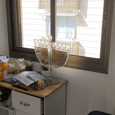 חלון אלומיניום עם חנוכייה על שולחן