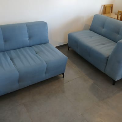 ספות כחולות בחדר עם רצפת אריחים אפורה