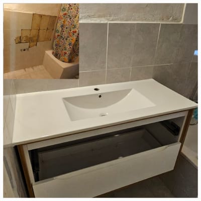 כיור מותקן עם ארון פתוח, קיר עם אריחים חסרים