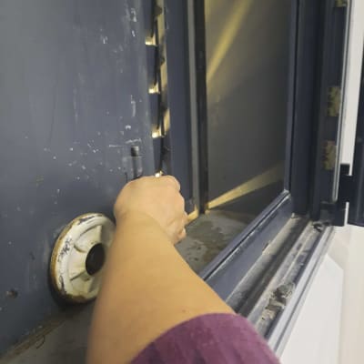 יד פותחת דלת כספת עם ידית עגולה