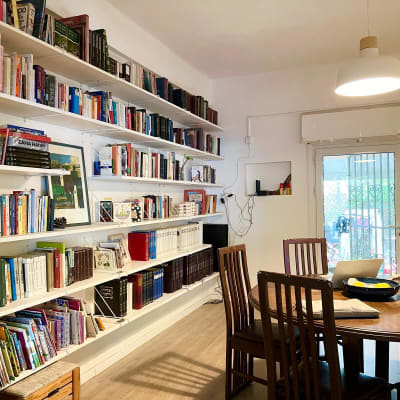 חדר עם מדפים מלאים בספרים, שולחן עגול וכיסאות