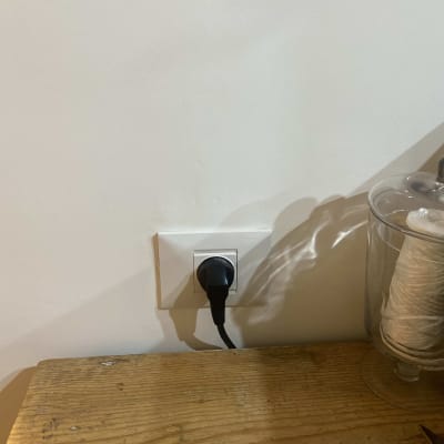 שקע חשמלי עם תקע מחובר בקיר לבן