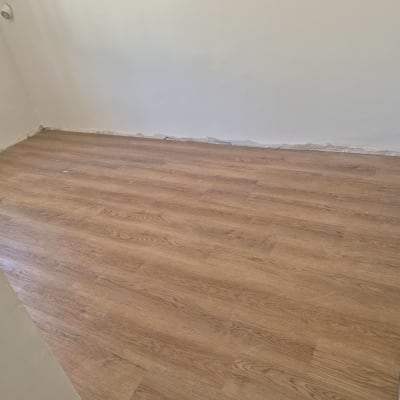 רצפת פרקט עץ בחדר ריק עם קיר לבן