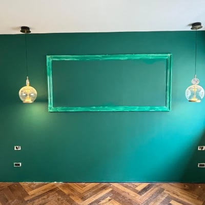 קיר ירוק עם מסגרת ותאורה דקורטיבית