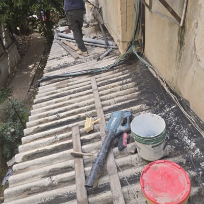עבודת איטום על גג עם כלים ודליים