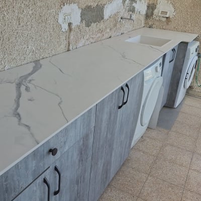 משטח שיש עם כיור ומכונת כביסה