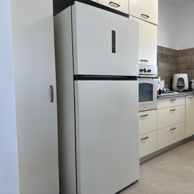 מקרר לבן במטבח מודרני עם ארונות בהירים