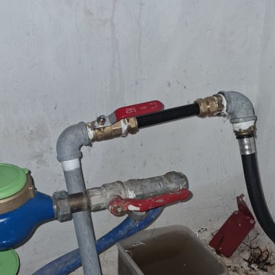 צינורות מים עם ברזים ודלי מתחת לכיור