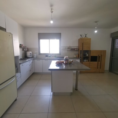 מטבח עם אי מרכזי, מקרר ולוח תבלינים על הקיר