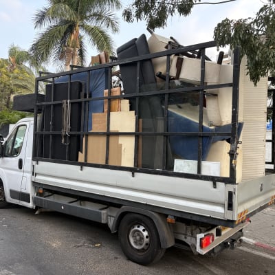 משאית פינוי תכולה עמוסה ברהיטים, ספות ומזרנים שפונות מדירה