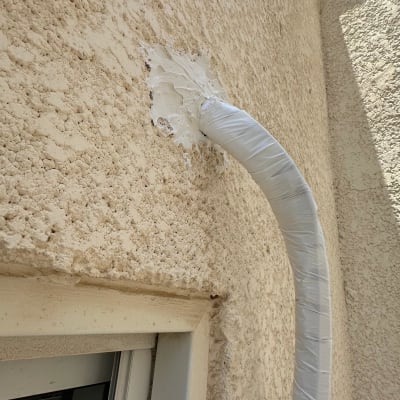 צינור מיזוג אוויר מחובר לקיר חיצוני