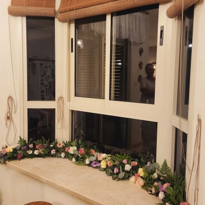 קישוט פרחים צבעוניים על אדן חלון