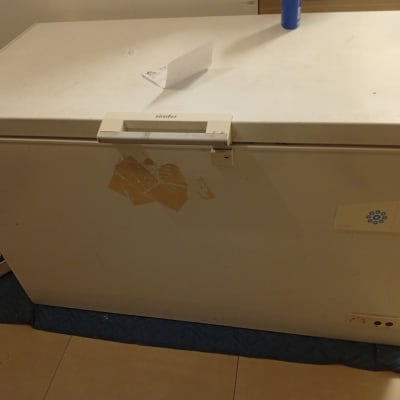 מקפיא לבן עם מדבקות על הרצפה