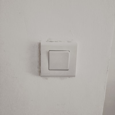 מתג חשמל לבן על קיר לבן
