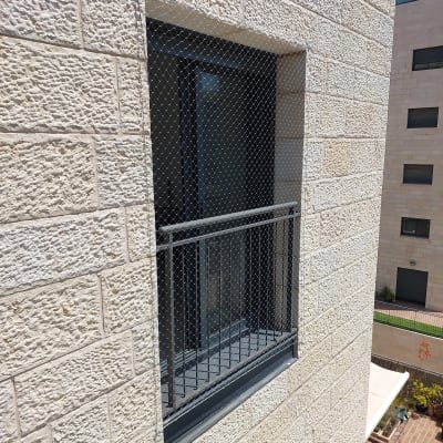 רשת מתכת על חלון למניעת כניסת יונים