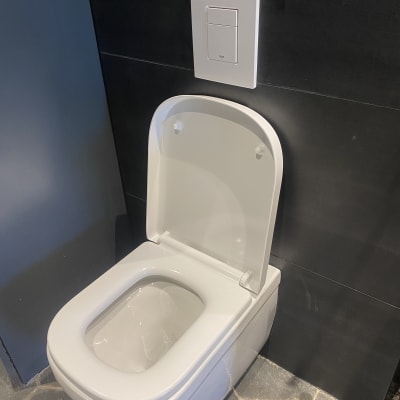 אסלה עם לחצן הדחה על קיר שחור