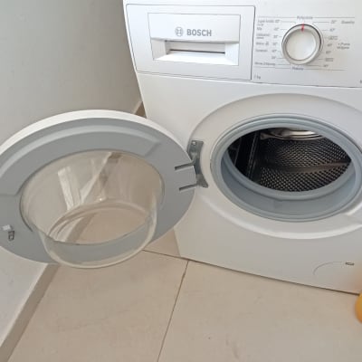 מכונת כביסה עם דלת פתוחה ותוף פנימי גלוי