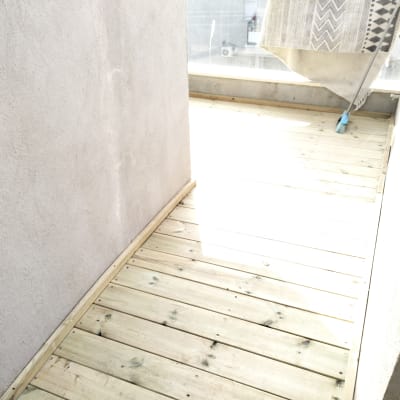 רצפת עץ חדשה במרפסת עם מטאטא בצד