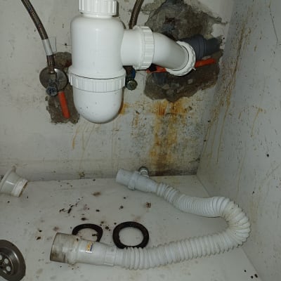 צנרת מתחת לכיור עם חיבורים ודליפות