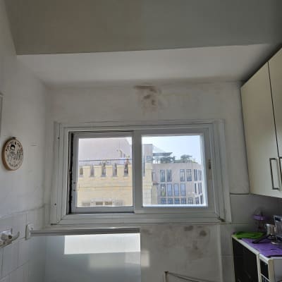 חלון עם תריסים סגורים למחצה במטבח