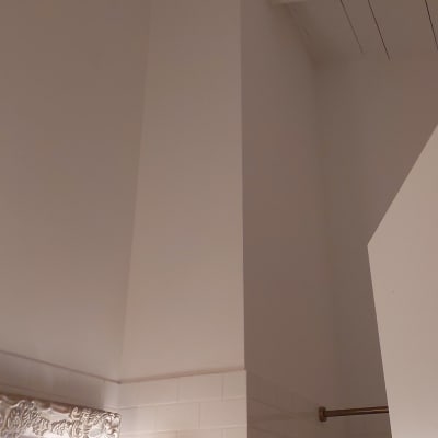 קיר צבוע בלבן עם אריחים ומנורה