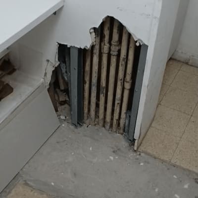 קיר עם חור וצינורות חשופים