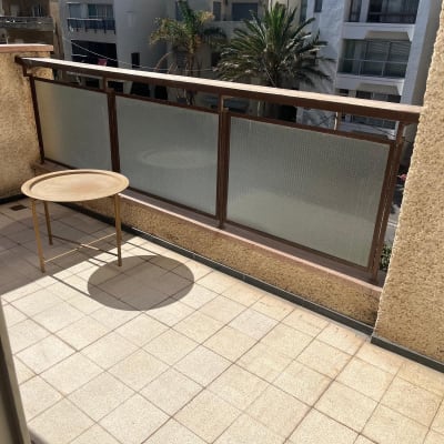 מרפסת עם שולחן קטן ונוף לבניינים