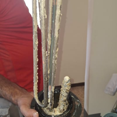 אדם מחזיק גוף חימום מלוכלך בדוד שמש