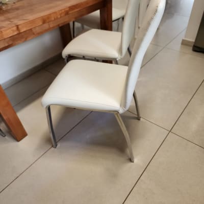 כיסאות מרופדים בלבן ליד שולחן עץ