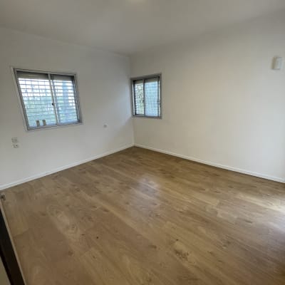 חדר עם קירות לבנים ורצפת עץ