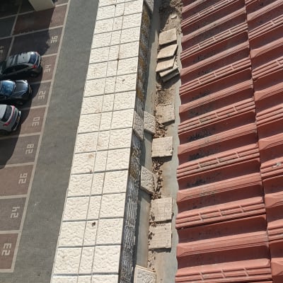 גג רעפים אדום עם אריחים לבנים בצד