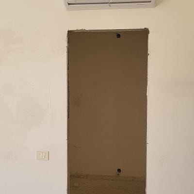 מזגן מותקן על קיר בחדר ריק עם חוטים חשופים