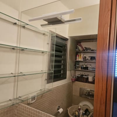 מדפי זכוכית תלויים על הקיר בחדר אמבטיה