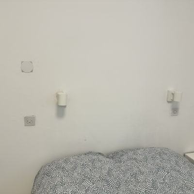 שקעי חשמל על קיר לבן בחדר שינה