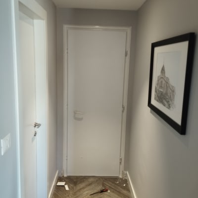 דלת לבנה במסדרון עם כלים על הרצפה