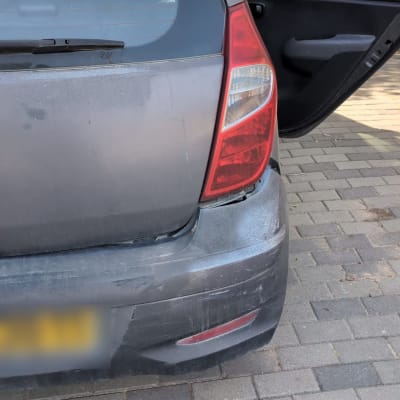 רכב עם פגוש אחורי פגום וחלון פתוח