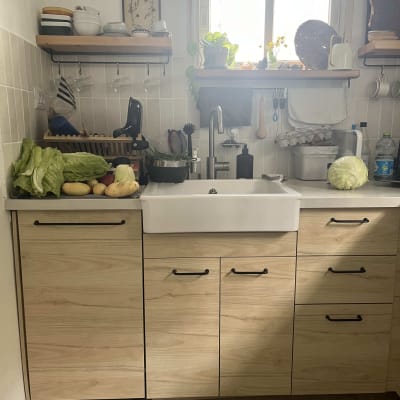 מטבח עם כיור, ירקות על השיש, מדפים עם כלים