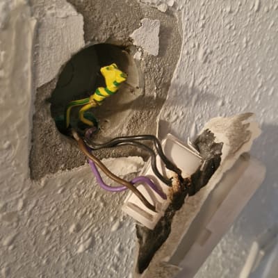 חוטי חשמל צבעוניים יוצאים מקיר שבור