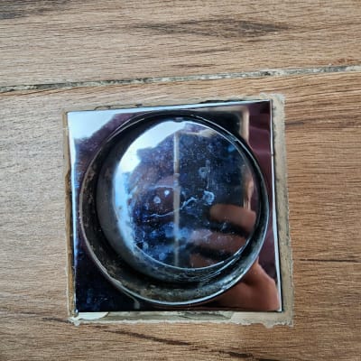 כפתור מתכת עגול על רקע עץ