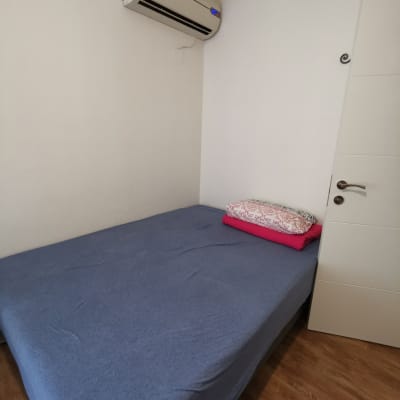 מיטה עם מצעים כחולים ומזגן על הקיר