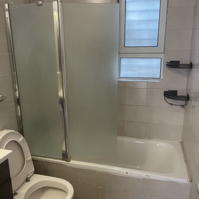 חדר אמבטיה עם מקלחת ושירותים נקיים