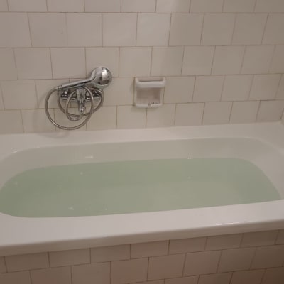 אמבטיה מלאה מים עם אריחי קרמיקה לבנים