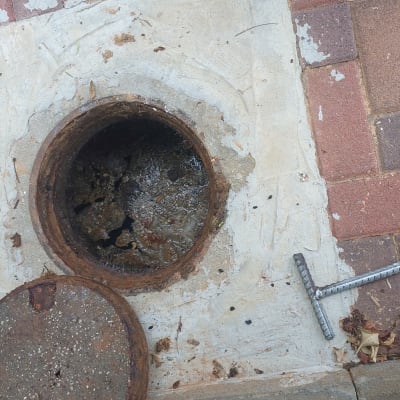 פתח ביוב פתוח עם מכסה ברזל וכלי עבודה